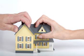 two hands on a house miniature symbolizing division of assets & property division